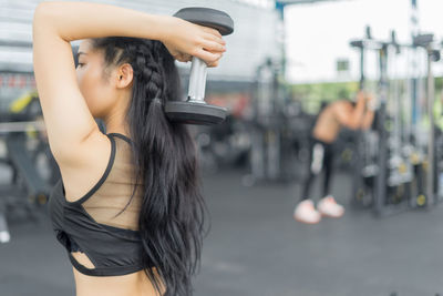 Side view of woman exercising at gym