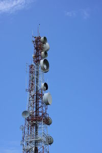 Low angle view of communications tower against blue sky