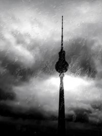Silhouette of tower against cloudy sky