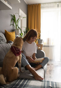 Woman with dog sitting at home