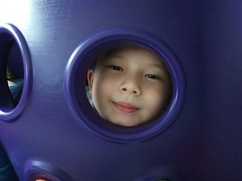 Portrait of cute boy seen through hole