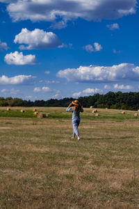 Background image of a young girl with a hat in a field with hay bales