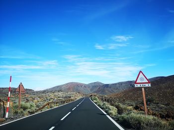 Road sign against blue sky