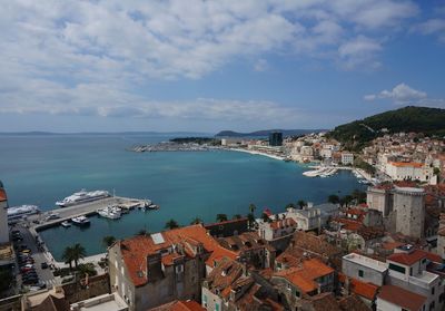 High angle view of townscape by sea against sky