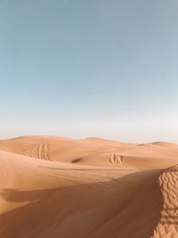 Sand dunes in desert against clear sky