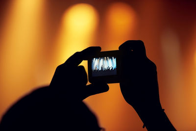 Cropped hand of woman holding illuminated light