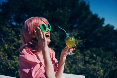 Young woman blowing bubbles in park