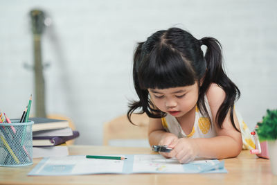 Side view of girl studying at table