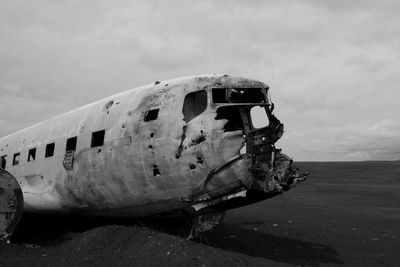 Abandoned airplane on runway against sky