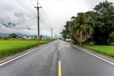 Road amidst trees against sky