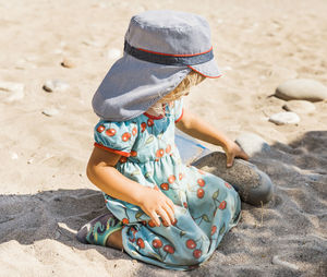 Full length of girl sitting on sand at beach