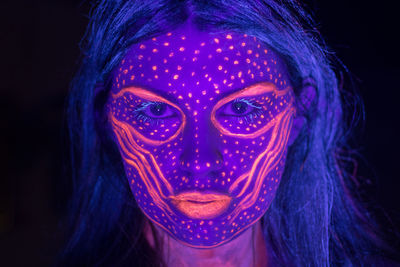 Close-up portrait of a woman in black background