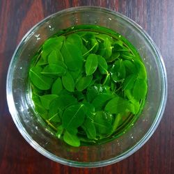 High angle view of green salad in glass bowl on table