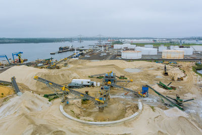 High angle view of construction site by sea against sky