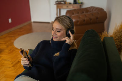 Low section of woman sitting on sofa at home