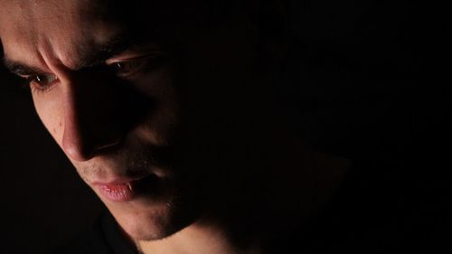 Close-up of man against black background