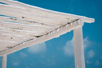 Low angle view of pier over sea against blue sky