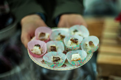 Midsection of person holding dessert in plate