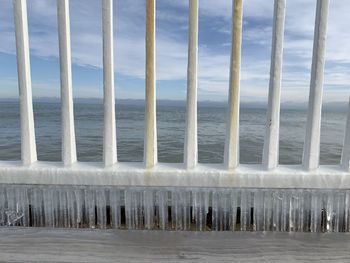 Wooden posts on beach against sky