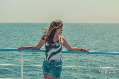 Full length of woman standing by sea against sky