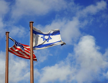 Low angle view of flags against blue sky