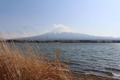 Scenic view of lake by mountains against sky