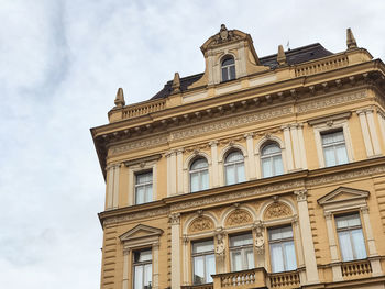 Low angle view of building against cloudy sky