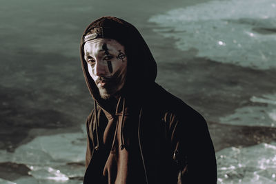 Portrait of young man standing against sea