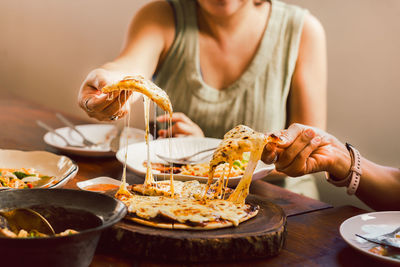 Woman hands taking slices of pizza with friends.