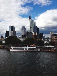 City skyline by river against sky