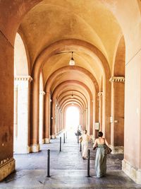 Rear view of women walking in colonnade