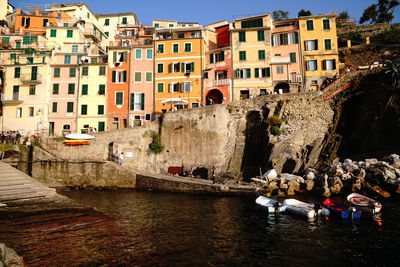 Boats in canal amidst buildings in city