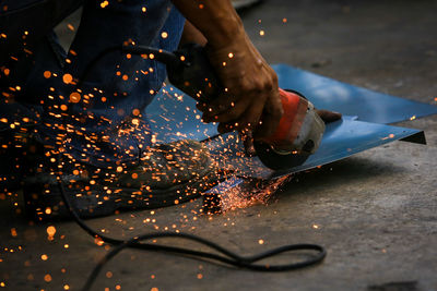 Close-up of person working on metal