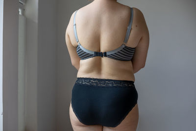 Rear view of woman standing against wall