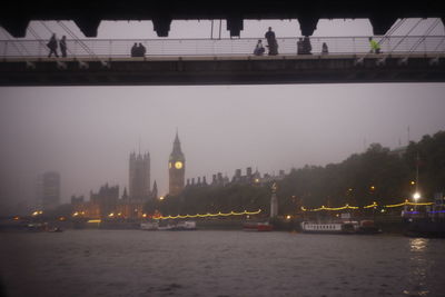 View of illuminated bridge over river at night