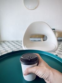 Close-up of person holding camera on table at home