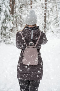 Rear view of woman standing in snow