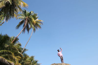 Low angle view of woman against blue sky