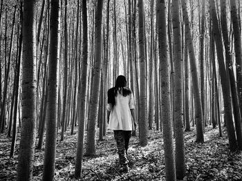 Rear view of woman walking in forest