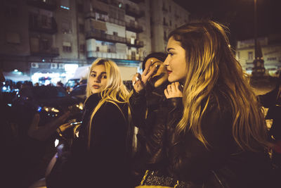 Women in illuminated city at night