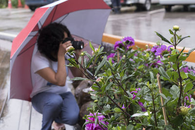 Woman sitting on purple flowering plant