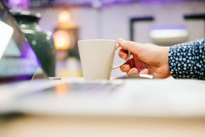 Man holding coffee cup on table