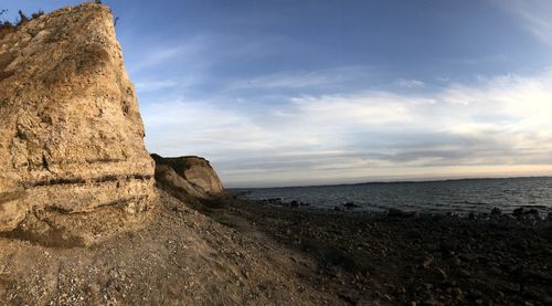 Rock formation on beach against sky