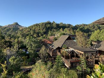 Scenic view of trees and houses against clear sky