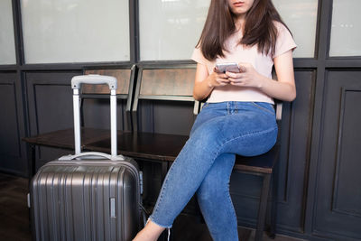 Young woman using mobile phone while sitting on seat