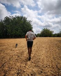 Rear view of woman walking on field