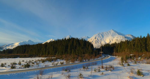 Scenic view of snowcapped mountains against blue sky