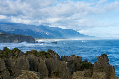 Scenic view of sea and mountains against sky