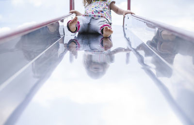 Low section of girl playing on slide at playground