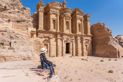 Woman sitting at historic building